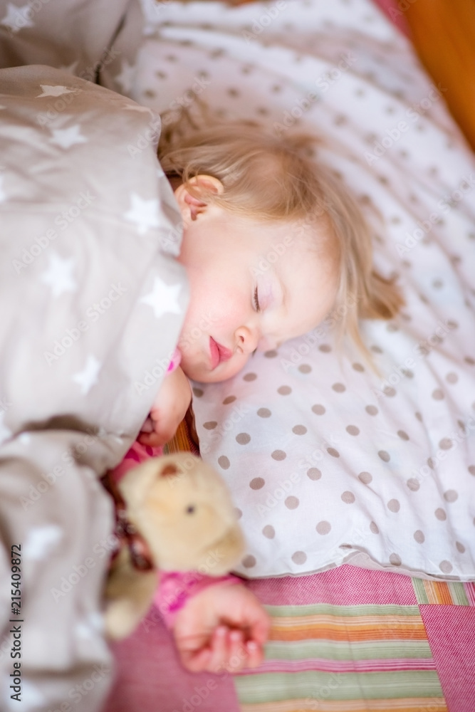 Sleeping baby with a toy bear.
