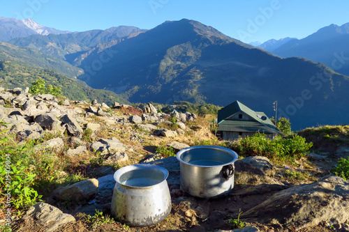 Fotografie Boiling water outdoors in big aluminium cooking pots surrounded by a beautiful m