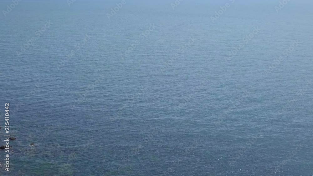 STATIC CROP Aerial, flying over a grassy bluff out into infinate blue bay waters STATIC CROP Aerial, flying over a grassy bluff out into infinate blue bay waters