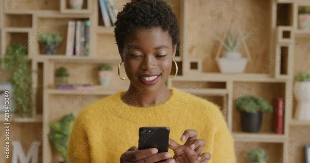 portrait stylish african american woman using smartphone browsing online messages smiling enjoying mobile communication technology slow motion