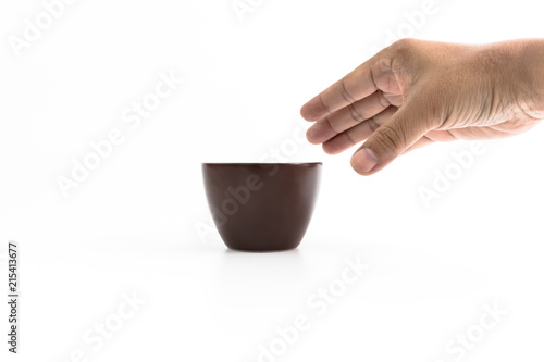 Hand of man is picking up the brown ceramic cup with light effected isolated