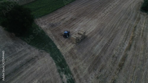 aerial view of wheat field in the countryside with tractor creating strawballs photo