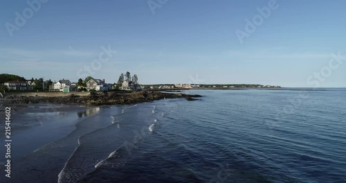 Waves brush the coastline of Kennebunk with beautiful homes in the distance.
