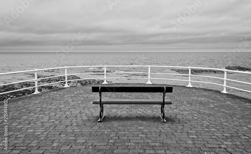A Seaside bench overlooking the sea on a cloudy day in Aberystwyth Wales