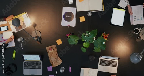 top view diverse business people in modern boardroom working late interacting planning ambitious market strategy for developing company time lapse close up track