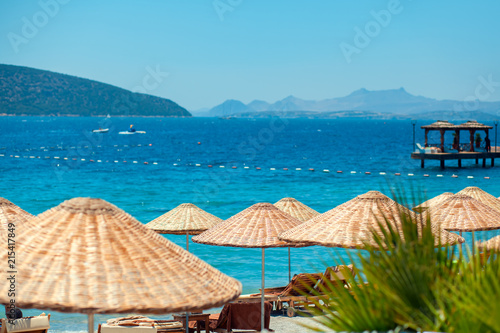 parasols and sunbeds on the beach in a hot summer day and sea background