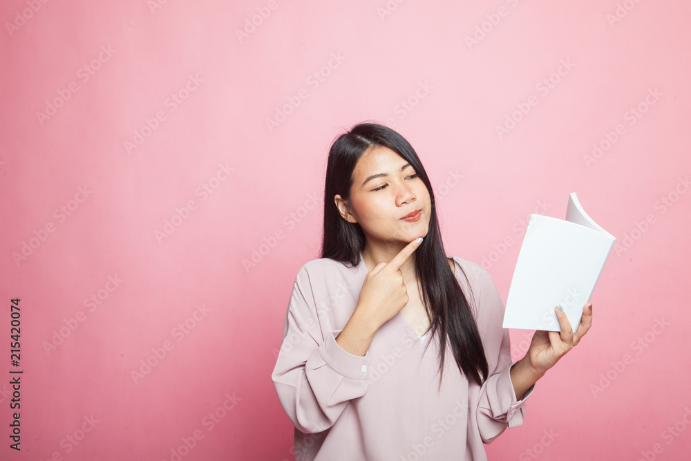Young Asian woman with a book is thinking. Young Asian woman with a book is thinking.
