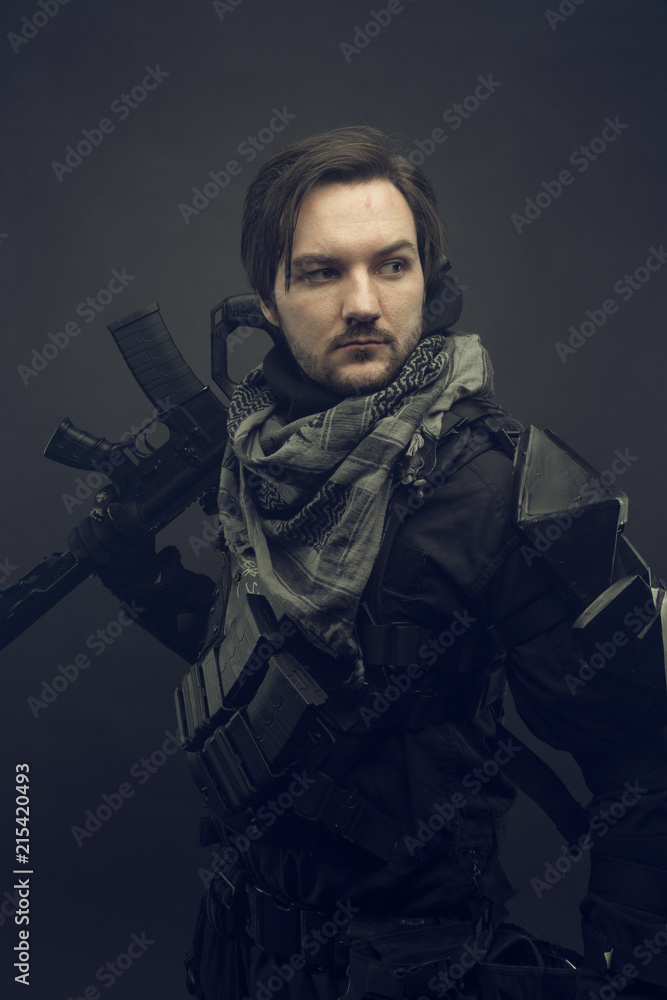 Cosplay futuristic solder. Portrait with machine gun. Dark background. Cosplay futuristic solder. Portrait with machine gun. Dark background.