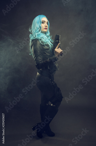 Cosplay futuristic action female with blue hair. Cosplay woman. Dark background, smoke. 