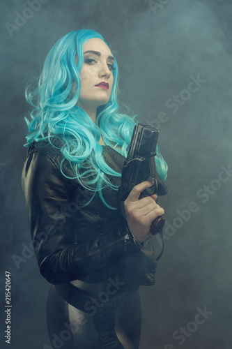 Cosplay futuristic action female with blue hair. Cosplay woman. Dark background, smoke. 