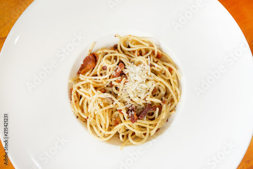 picy spaghetti bacon - spaghetti with bacon, chilli, garlic, tomato, black  olive on top Parmesan cheese and parsley. photo