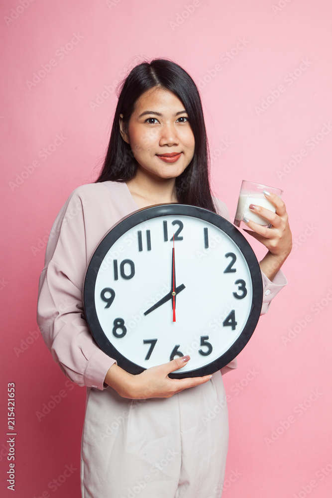 Healthy Asian woman drinking glass of milk hold clock. Healthy Asian woman drinking glass of milk hold clock.