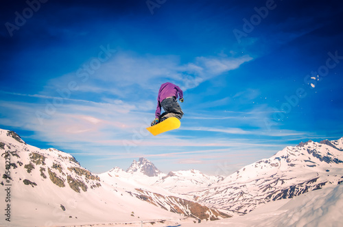 Snowboarder jumping with yellow board photo