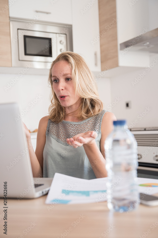Woman gesturing and talking at a laptop Woman gesturing and talking at a laptop