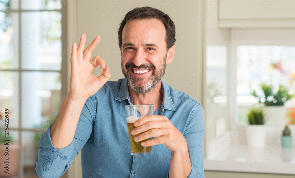 Middle age man drinking beer doing ok sign with fingers, excellent symbol Middle age man drinking beer doing ok sign with fingers, excellent symbol