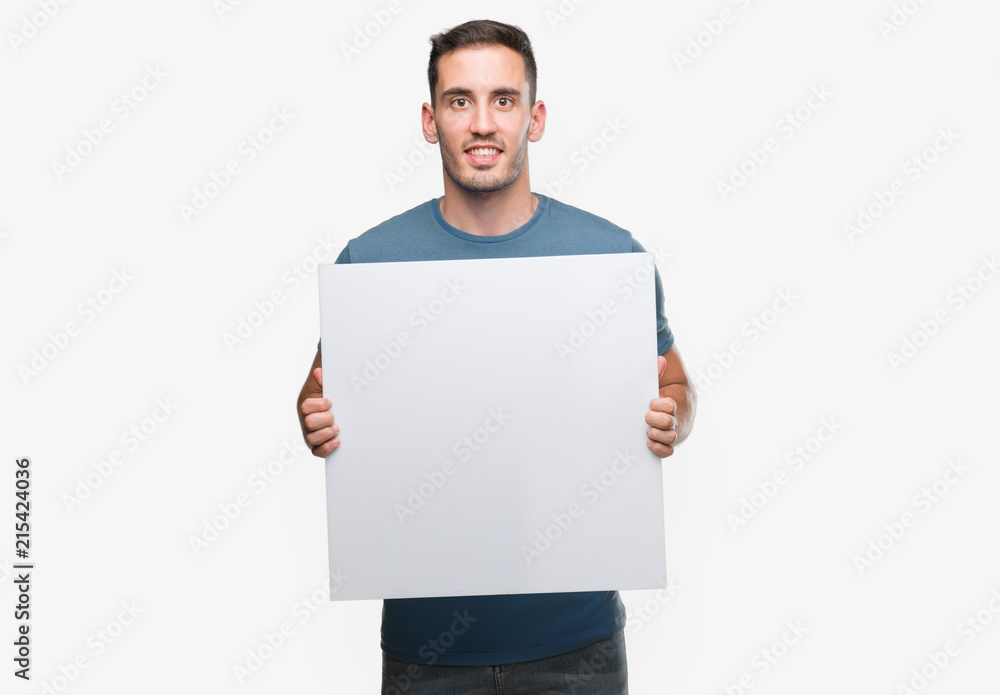 Handsome young man holding advertising banner with a happy face standing and smiling with a confident smile showing teeth Handsome young man holding advertising banner with a happy face standing and smiling with a confident smile showing teeth
