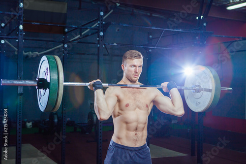 Muscular fitness man preparing to deadlift a barbell over his head in modern fitness center.Functional training.Snatch exercise. Cross style fit, deadlift