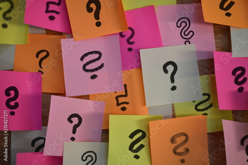 Handwritten different question marks on red, pink, white, yellow and orange sticky notes 
