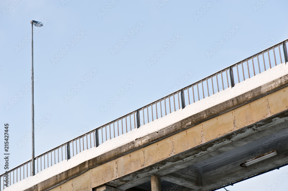 Bridge with railing and street light against blue sky. Bridge with railing and street light against blue sky.