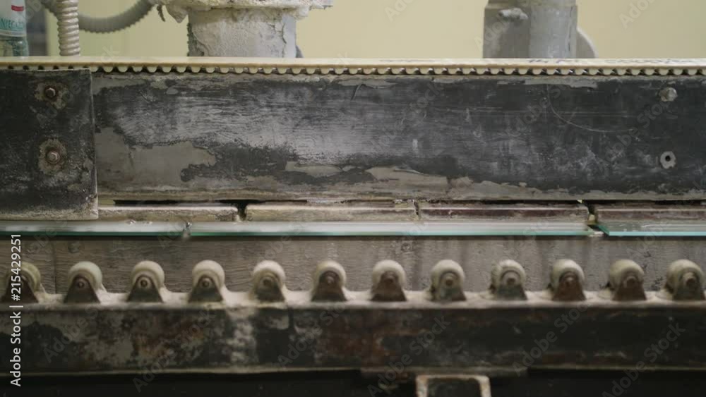 An industrial machine in a factory for cutting glass. Close-up shot An industrial machine in a factory for cutting glass. Close-up shot