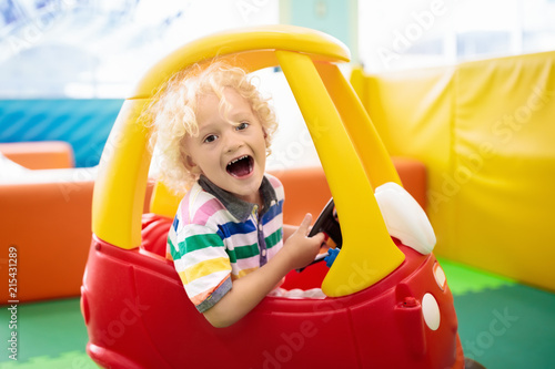 Child riding toy car. Little boy with toys.