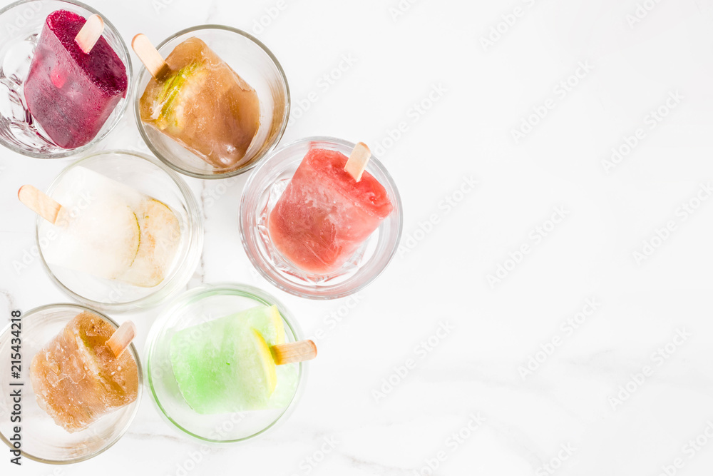 Summer party food ideas, frozen boozy alcohol cocktails popsicles - Prosecco, Vodka lime mojito, Champagne, Bellini, Margarita, Negroni etc white marble table copy space Summer party food ideas, frozen boozy alcohol cocktails popsicles - Prosecco, Vodka lime mojito, Champagne, Bellini, Margarita, Negroni etc white marble table copy space
