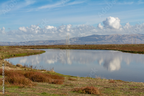 Puffy Clouds Reflected in a Slough on the Edge of San Francisco Bay, Palo Alto, California photo