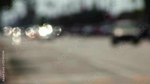 Sunlight reflecting off cars in the distance creates sparkling bokeh during the day, sequence 1of 2. photo