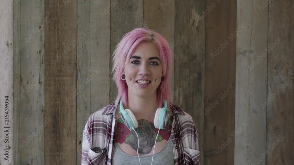 young punk girl portrait of pretty woman with pink hairstyle smiling happy looking at camera wooden background independent urban female body art tattoo young punk girl portrait of pretty woman with pink hairstyle smiling happy looking at camera wooden background independent urban female body art tattoo