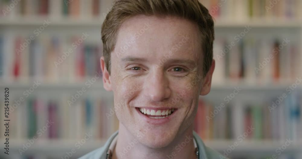 close up portrait young red head man student laughing enjoying relaxed college lifestyle in bookshelf background close up portrait young red head man student laughing enjoying relaxed college lifestyle in bookshelf background