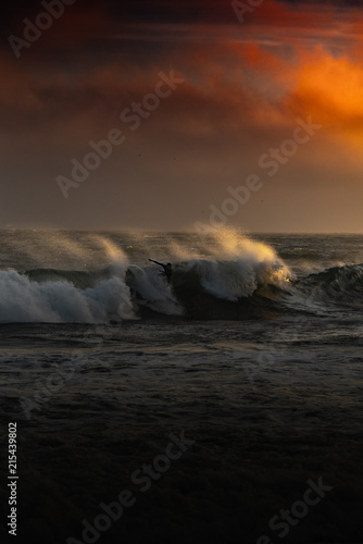 surfer riding wave at sunset  © Abraham