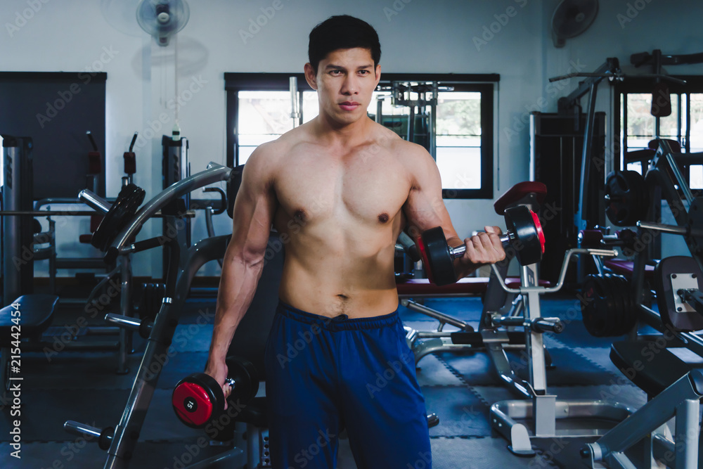 Asian muscular men are lifting weights in the gym. Asian muscular men are lifting weights in the gym.