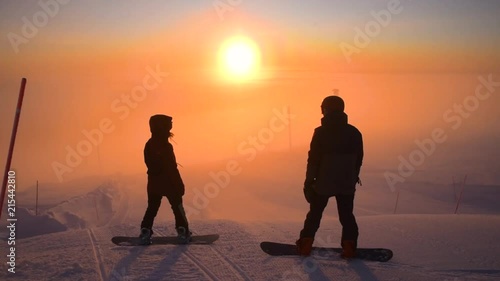 Snowboarders ready to ride down in beautiful sunlight during polarnight time in Lapland Finland. photo