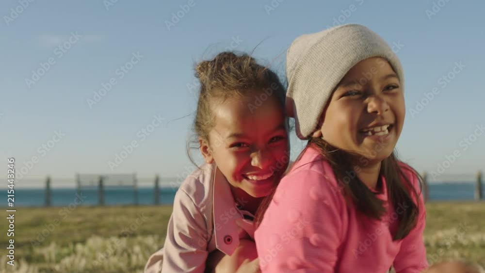 close up portrait of happy mixed race girls sitting playing laughing enjoying seaside park close up portrait of happy mixed race girls sitting playing laughing enjoying seaside park