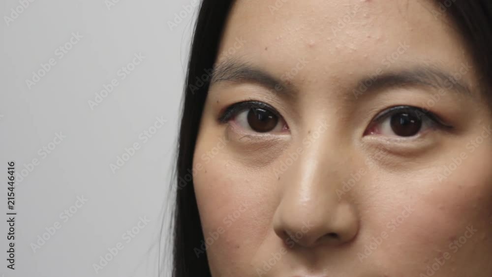 close up beautiful young asian woman face turns looking at camera eyes blinking isolated on white background close up beautiful young asian woman face turns looking at camera eyes blinking isolated on white background
