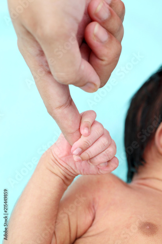 Newborn baby boy gripping mothers finger 