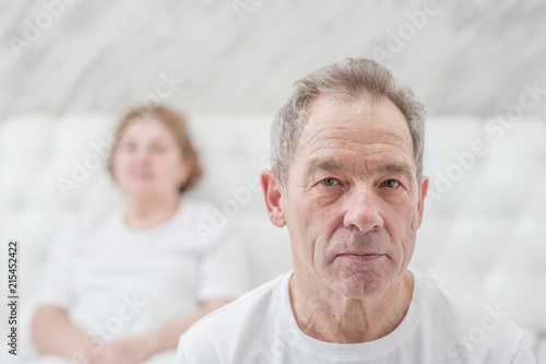 Canvas Print sad man and woman - conflict of an elderly couple on the bed in the bedroom