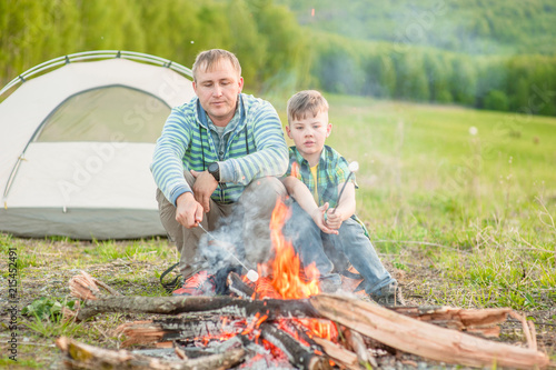 father and son by the fire near the tent