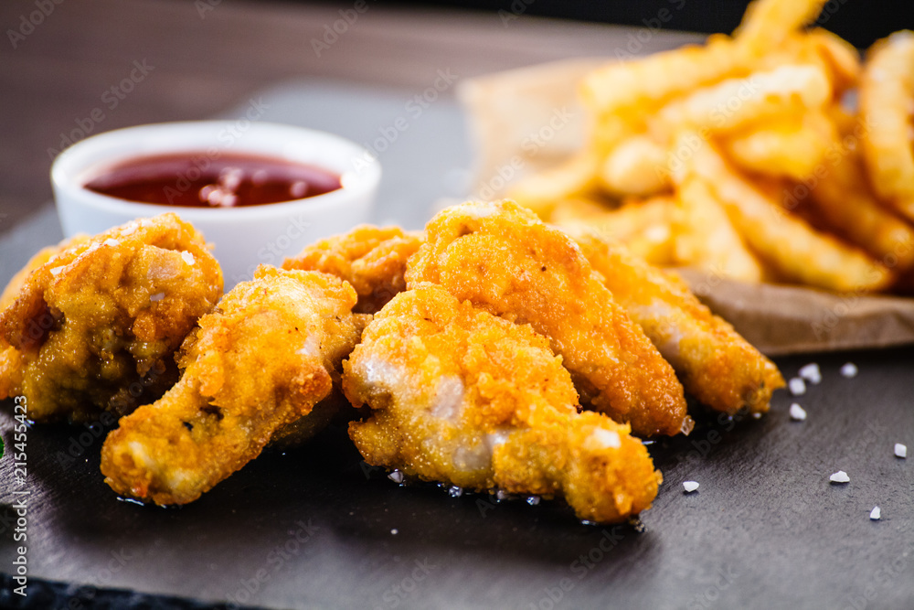 Chicken nuggets with french fries on black stone plate Chicken nuggets with french fries on black stone plate