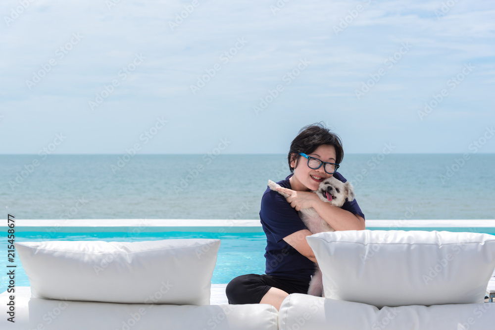 Woman and dog on white bed at pool seaside the sea