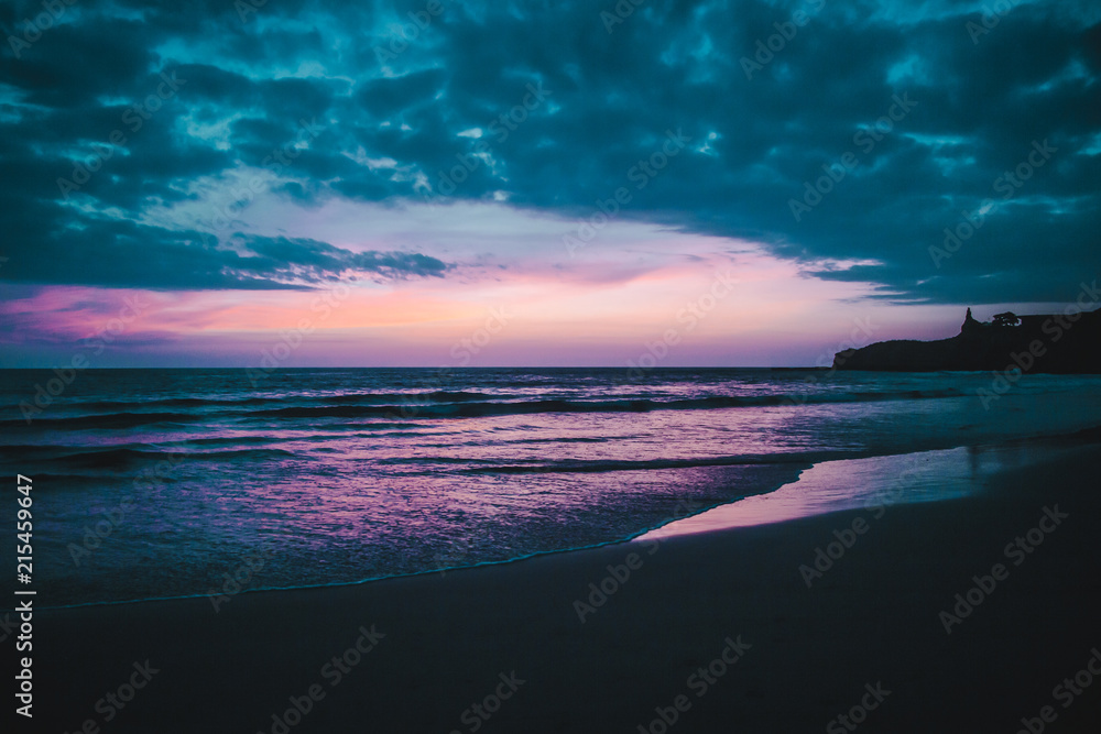 Purple sunset over the Pacific Ocean and beach of Montañita, Ecuador, a popular destination for surfers