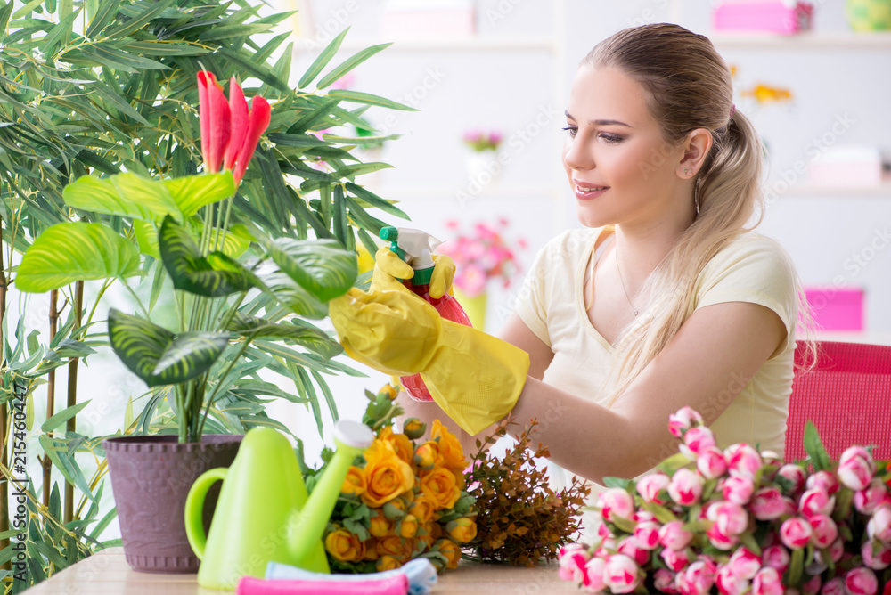 Young woman watering plants in her garden