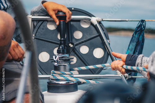 Woman pulling rigging rope for sail on sailboat