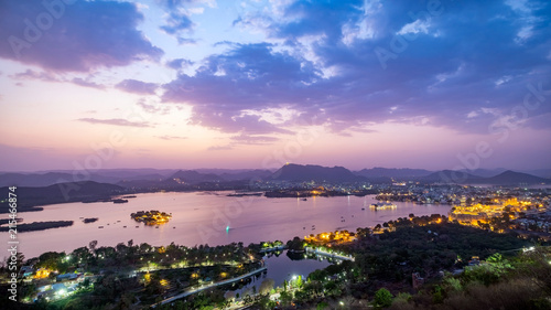Udaipur city at lake Pichola in the evening, Rajasthan, India. View from the mountain viewpoint see the whole city reflected on the lake.