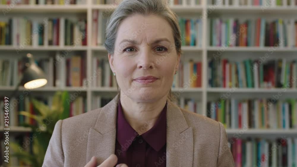 portrait of mature business woman executive looking at camera smiling confident enjoying successful corporate career proud female in library bookshelf background portrait of mature business woman executive looking at camera smiling confident enjoying successful corporate career proud female in library bookshelf background