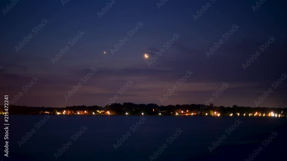 Moon and a planet rising over hills on a river. Moon and a planet rising over hills on a river.