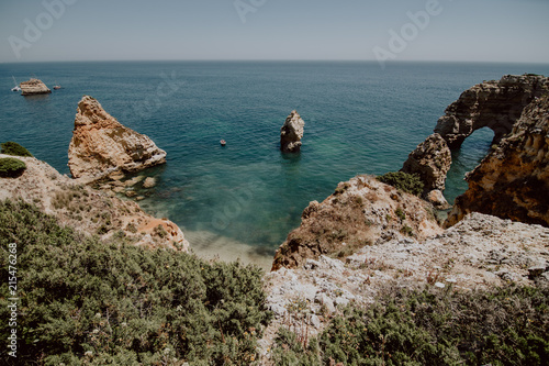 Natural arches of Praia da Marinha in Algarve, Portugal, Europe. Sunbeams over Marinha Beach one of the 100 most beautiful beaches in the world. Famous place for summer holidays photo