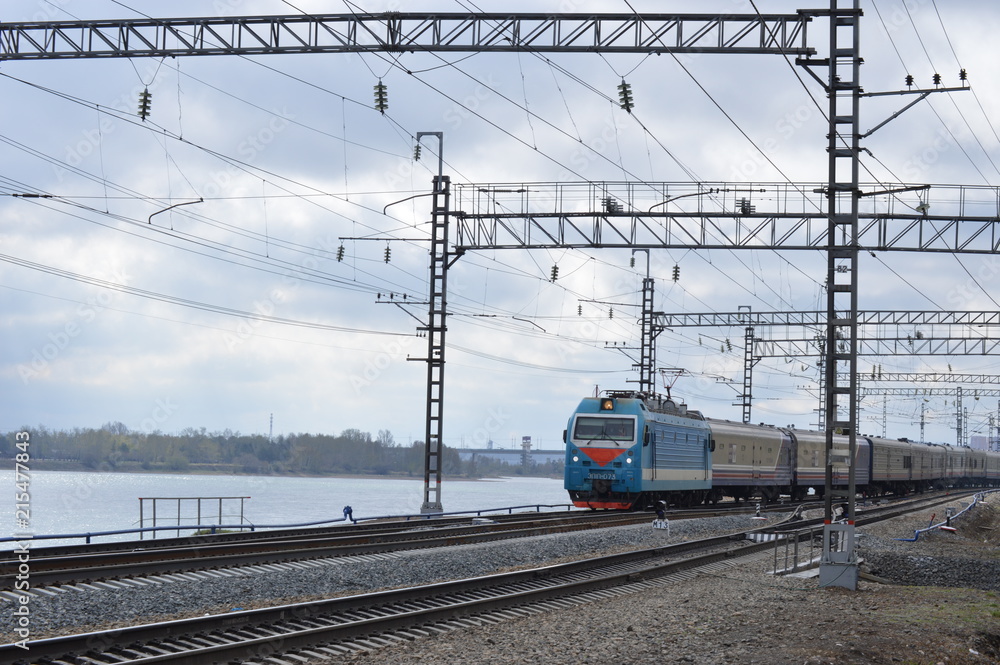 There is a train along the river. There is a train along the river.