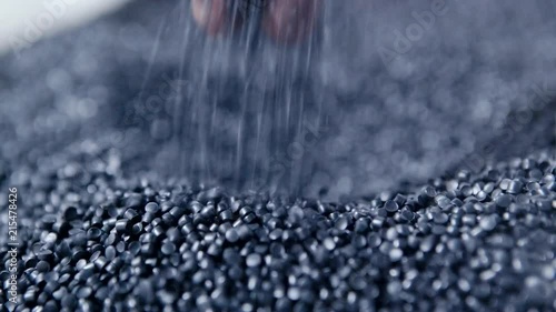 Hands lift white polymer granules from a cloth bag in a garbage recycling plant. Plastic pellets are crumbling or poured from the palms. Raw materials for recycled plastic are used in manufacturing.