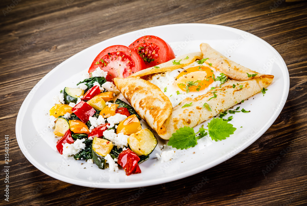Crepes with eggs on wooden background Crepes with eggs on wooden background